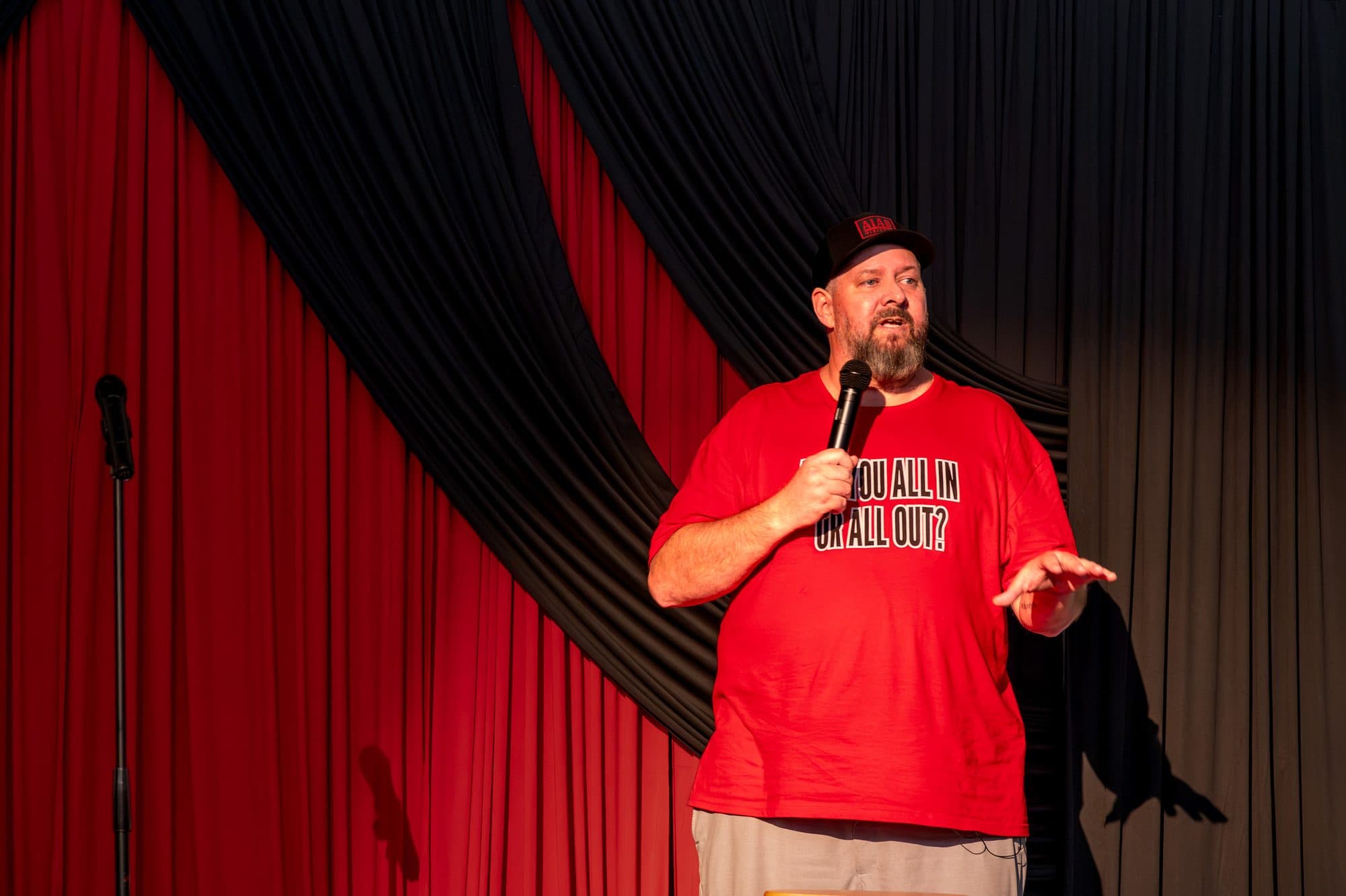 Speaker addressing the crowd at the Mic Drop Masters 2026 fundraiser.