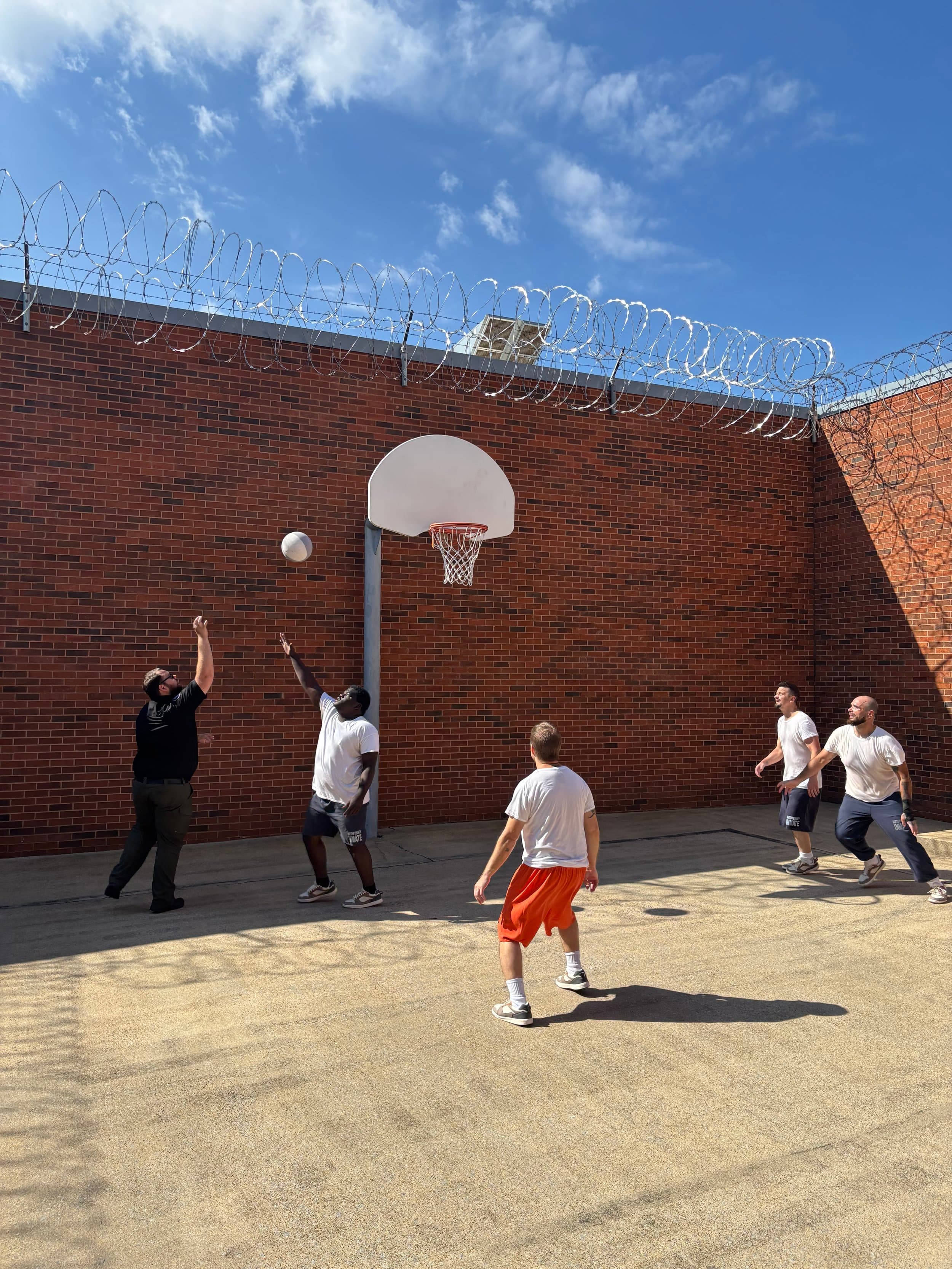 Group of men playing basketball outdoors on a court